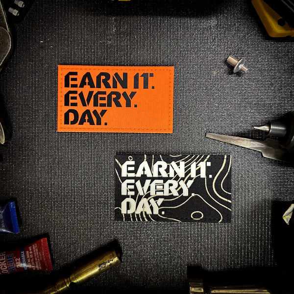 Earn It Every Day LC (orange blaze or black topo variant)